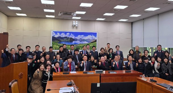 서울 여의도 국회 외교통일위원회 회의실에서 김석기 위원장과 시민들이 '2025 경주 APEC 정상회의 지원 특별법' 통과를 축하하며 기념촬영을 하고 있다. 경주시 제공