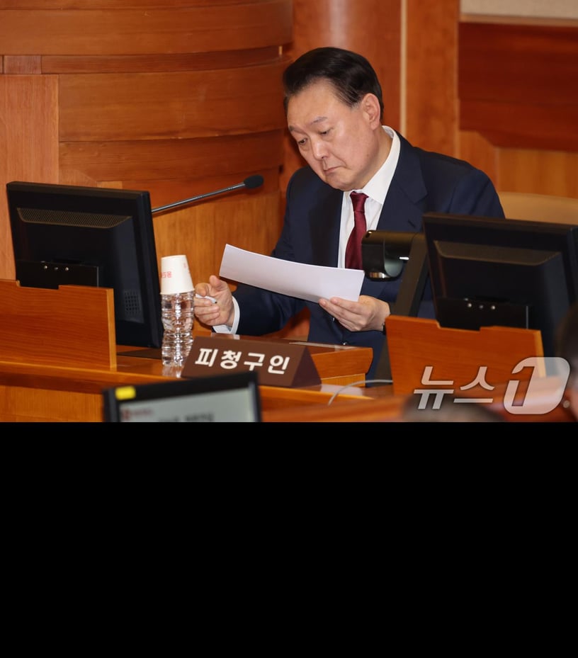 윤석열 대통령이 23일 오후 서울 종로구 헌법재판소 대심판정에서 열린 탄핵심판 4차 변론기일에 출석해 메모지를 살펴보고 있다. 2025.1.23/뉴스1 ⓒ News1 사진공동취재단